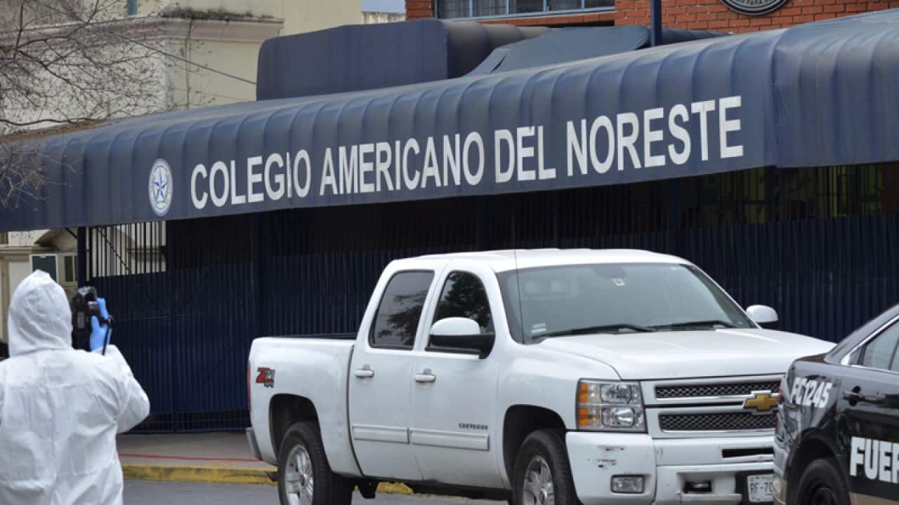 A forensic investigator walks outside a private school in Monterrey