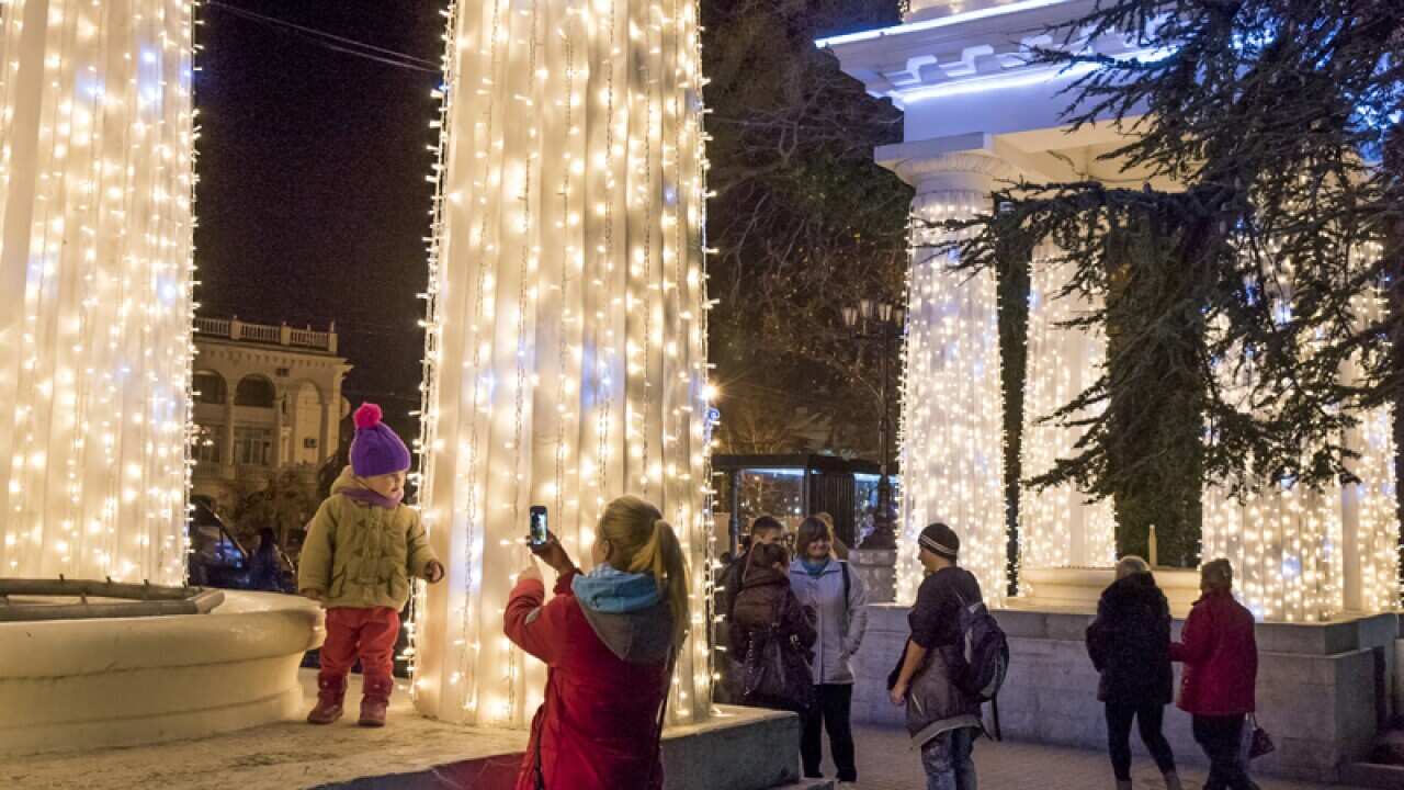 People take pictures in Nakhimov's Square in Sevastopol, Crimea