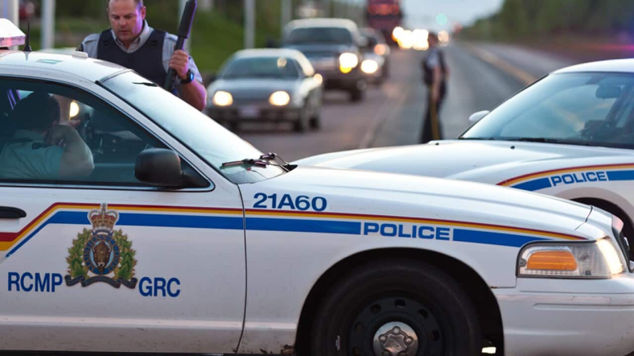Royal Canadian Mounted Police officers create a perimeter