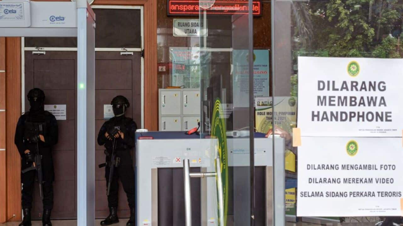 Police stand guard outside a courtroom during the trial of Zulkarnaenat a district court in Jakarta on 19 January, 2022.
