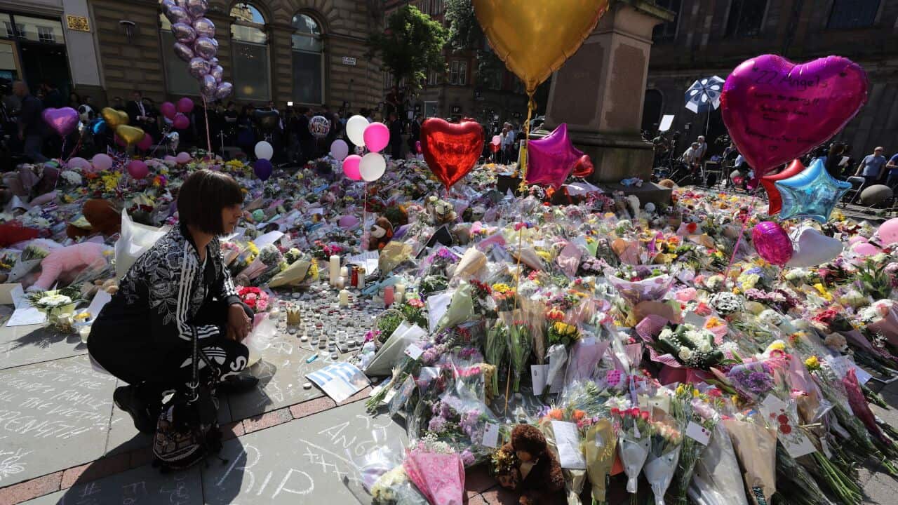 A woman looks at messages and tributes in St Ann's Square, Manchester, to remember the victims of the terror attack in the city