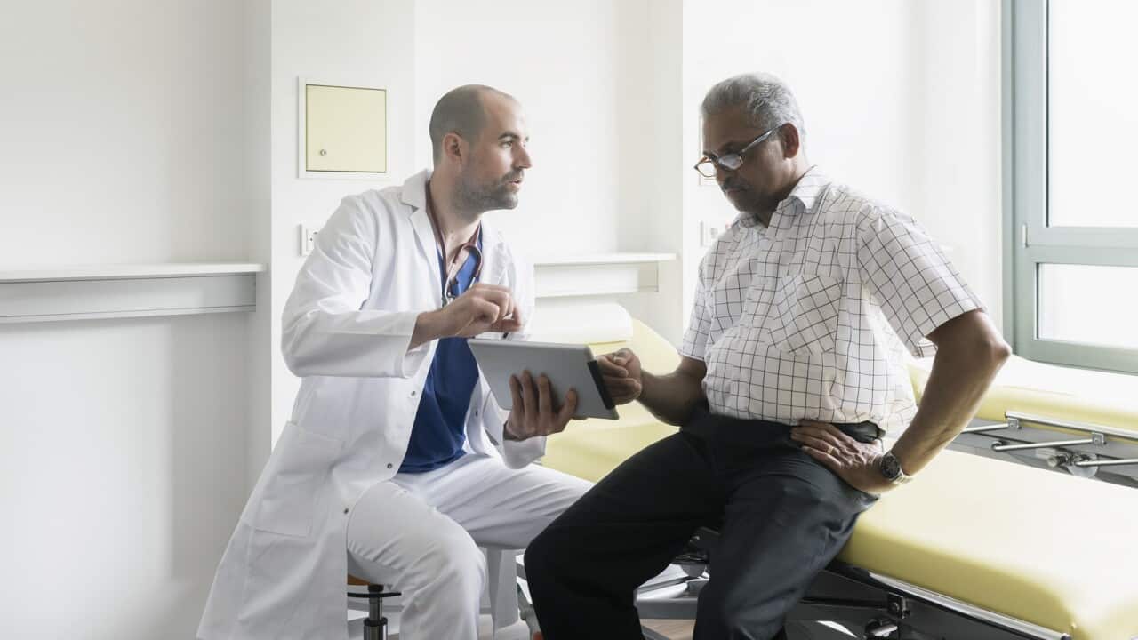 Doctor and senior patient discussing medical test results using digital tablet