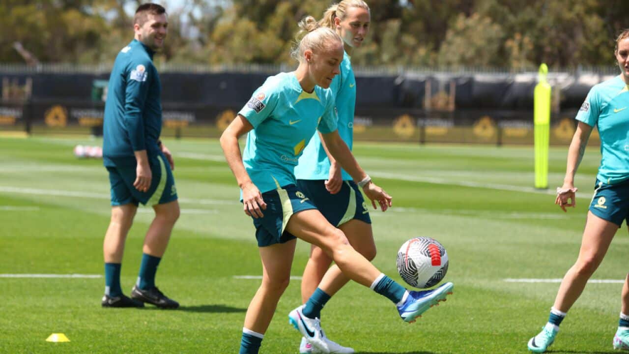 A female footballer kicking the ball at training