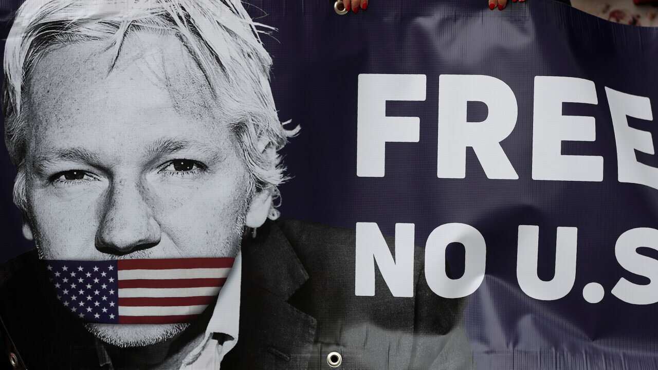 Assange supporters hold a banner to protest outside Westminster Magistrates Court in London, Friday, June 14, 2019.