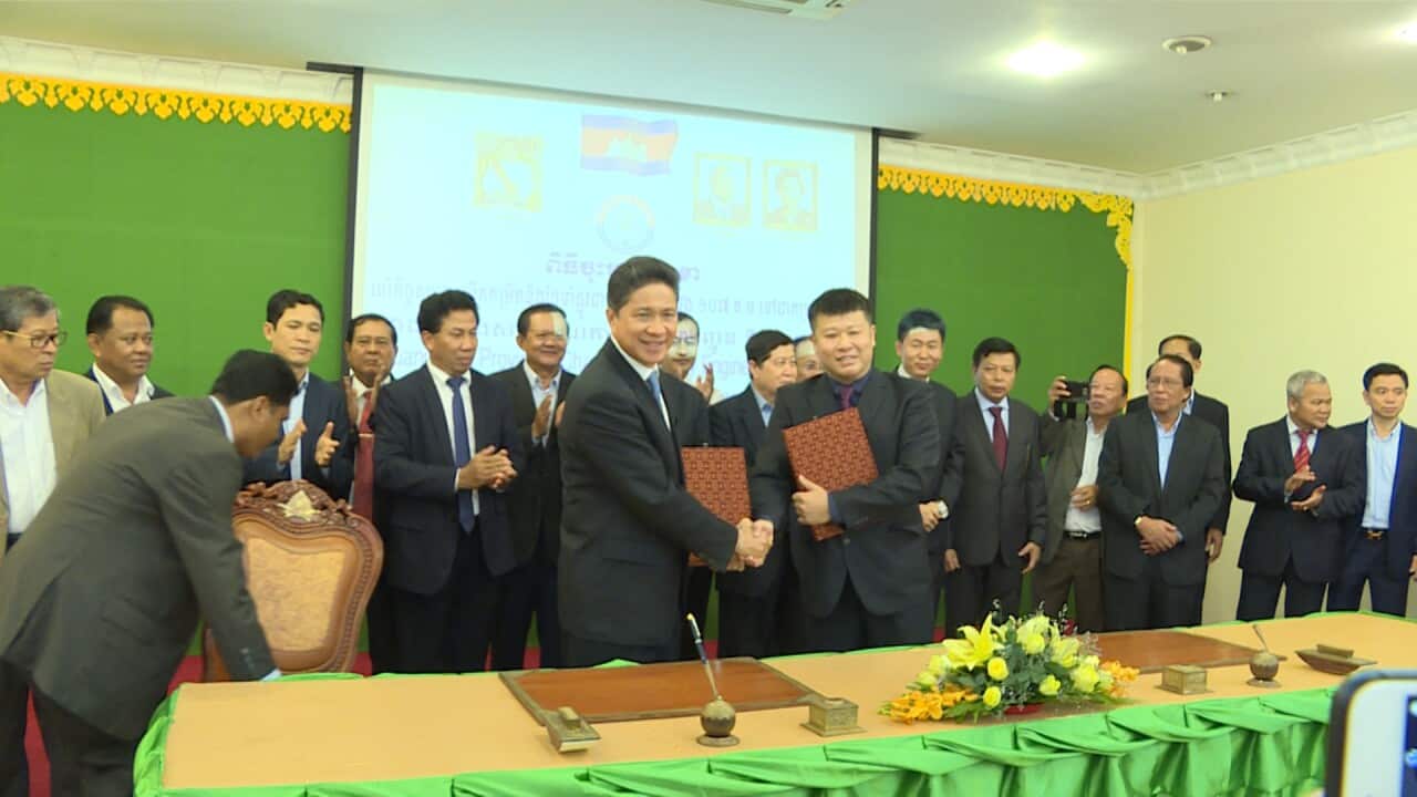 Minister Sun Chan Thol signs agreement.