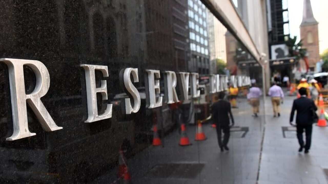 A pedestrian walks past the Reserve Bank of Australia in Sydney