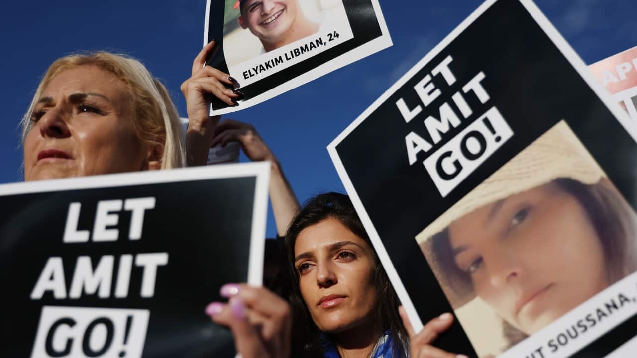 Women hold posters saying "Let Amit go"