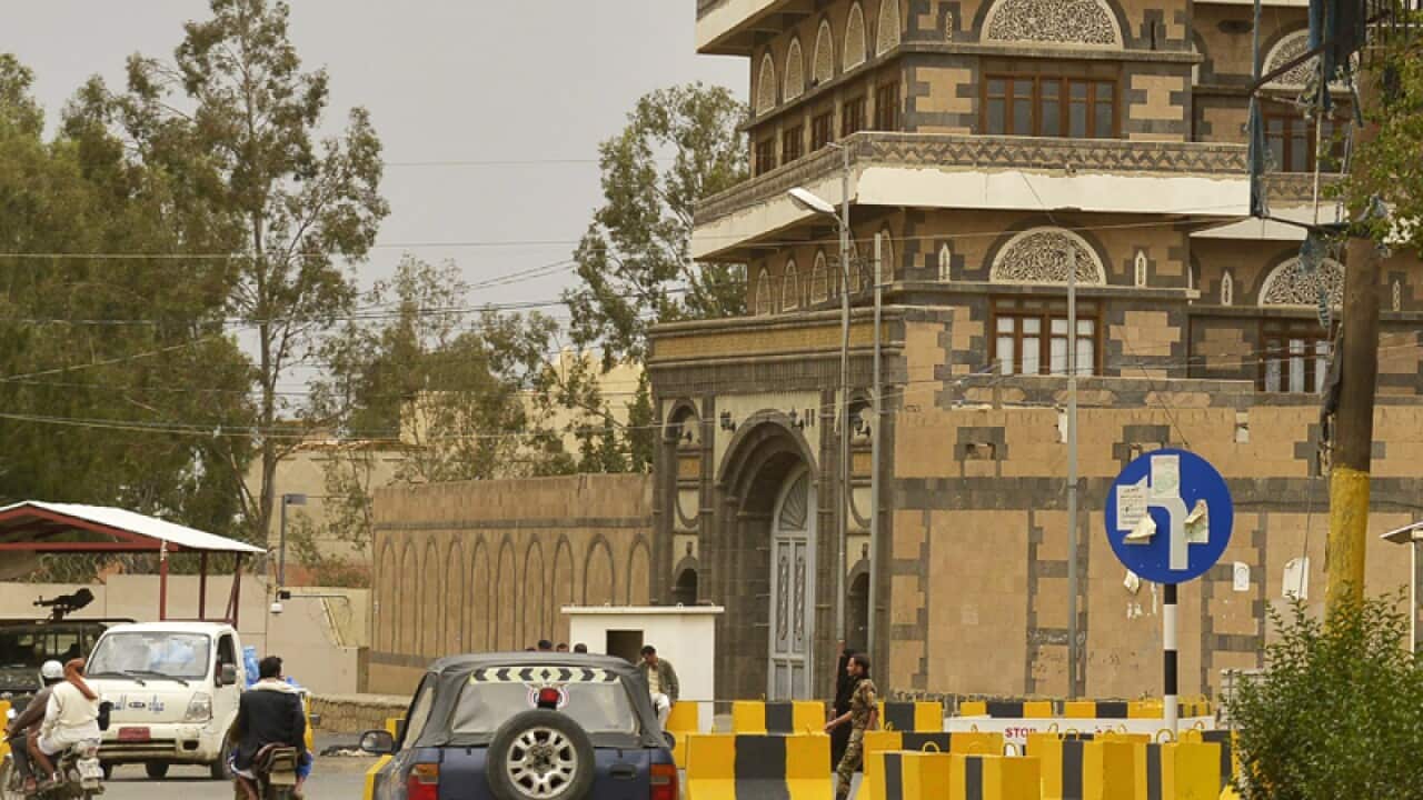 Vehicles drive past barriers blocking access to the US embassy