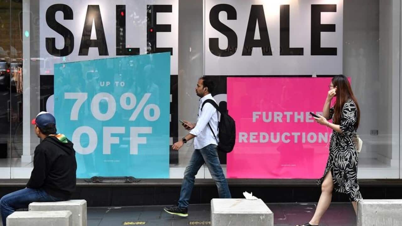 Pedestrians walk past a women's fashion store in Sydney.