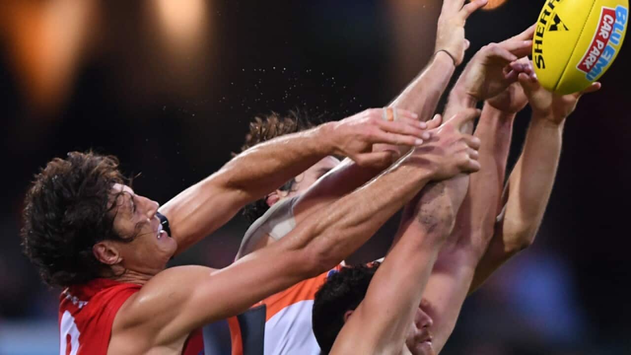 Sydney Swans and GWS Giants players contest the ball