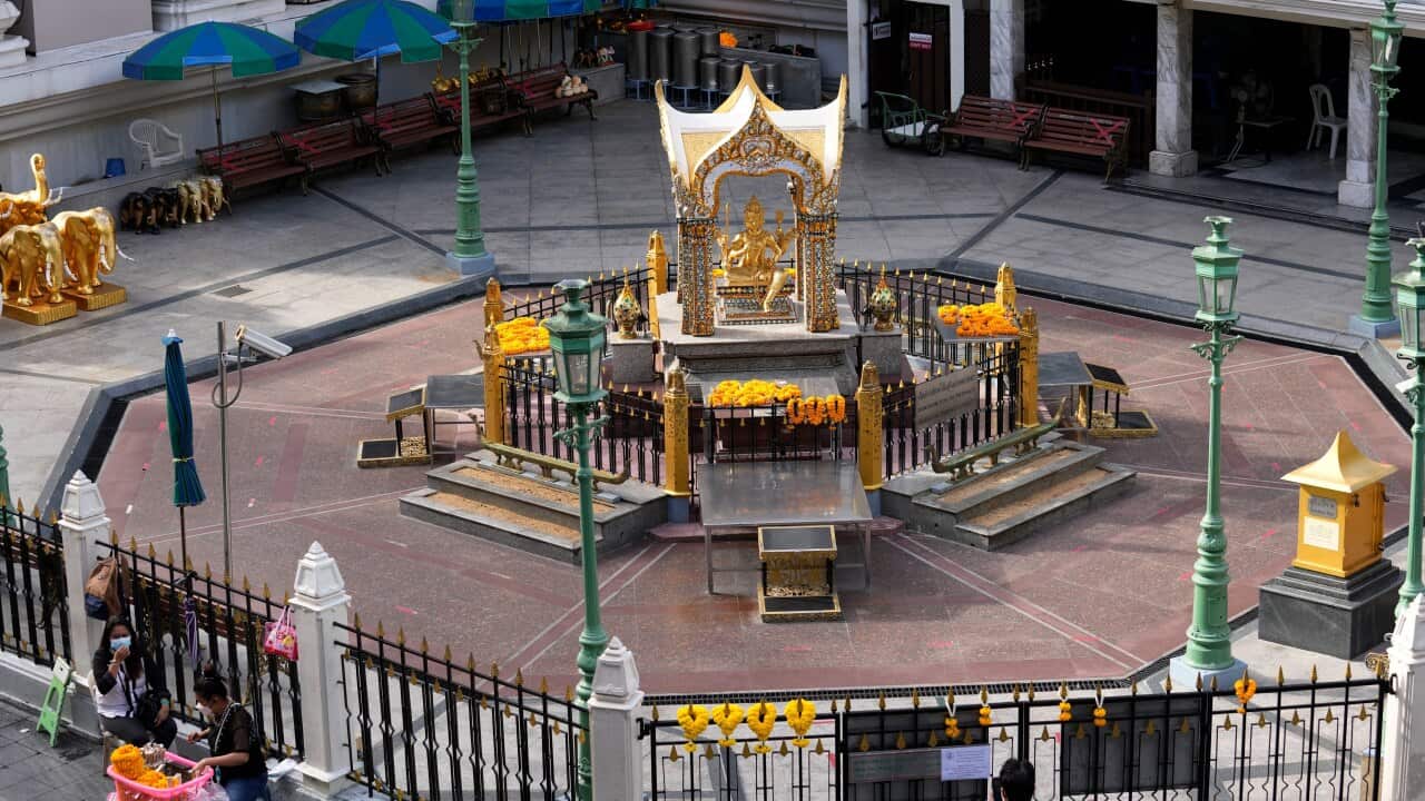 Flower vendors sit outside Erawan Shrine in Bangkok, Thailand on Aug. 3, 2021. As Thailand battles a punishing COVID-19 surge with nearly 20,000 new cases every day, people who depend on tourism struggle in what was one of the most-visited cities