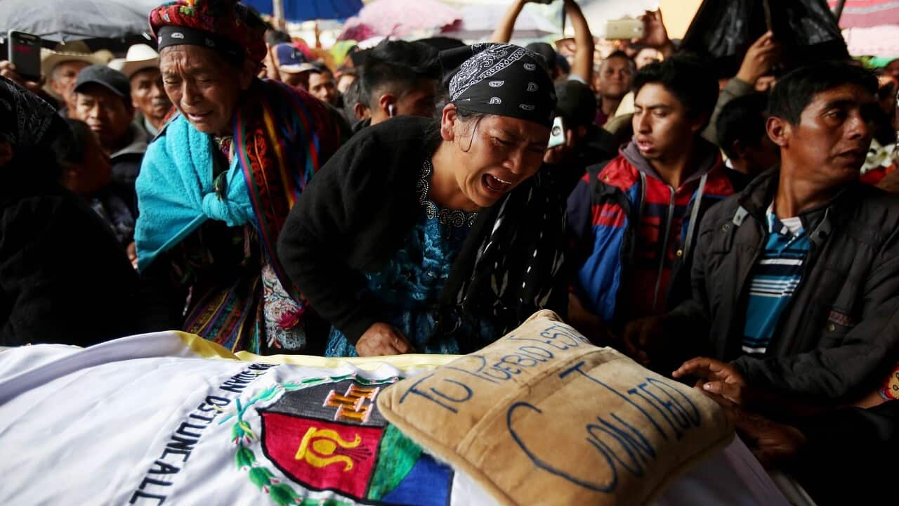 Mourners next to the coffin