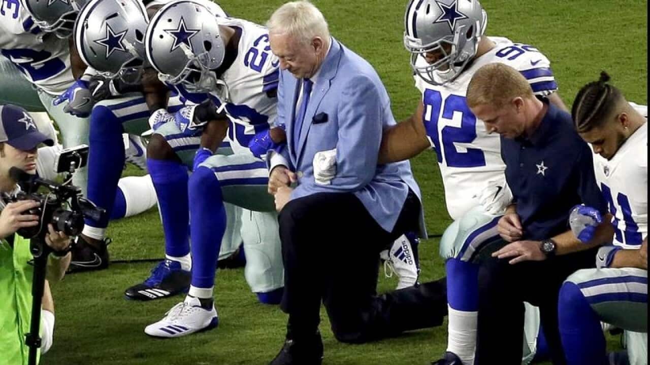 Dallas Cowboys owner Jerry Jones kneels with his players.