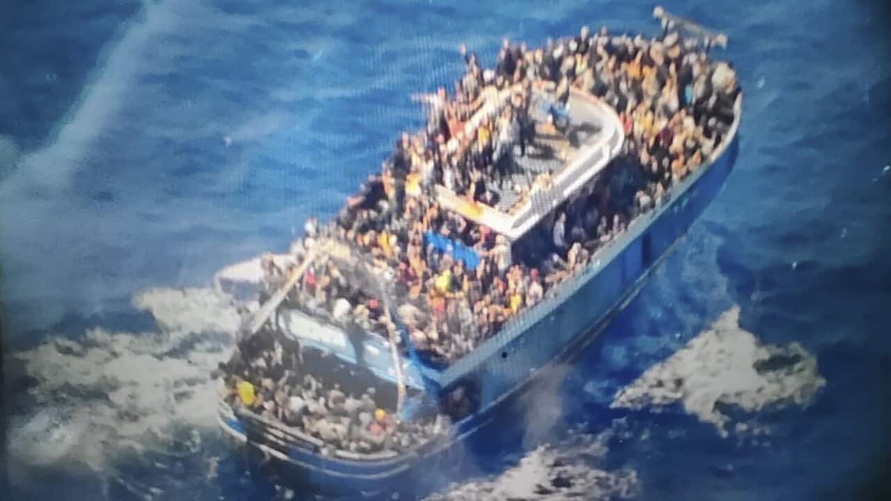 The capsized boat carrying scores of people on deck.