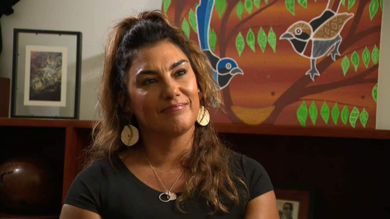 lidia thorpe smiling and sitting in an office with her bookcase behind her,