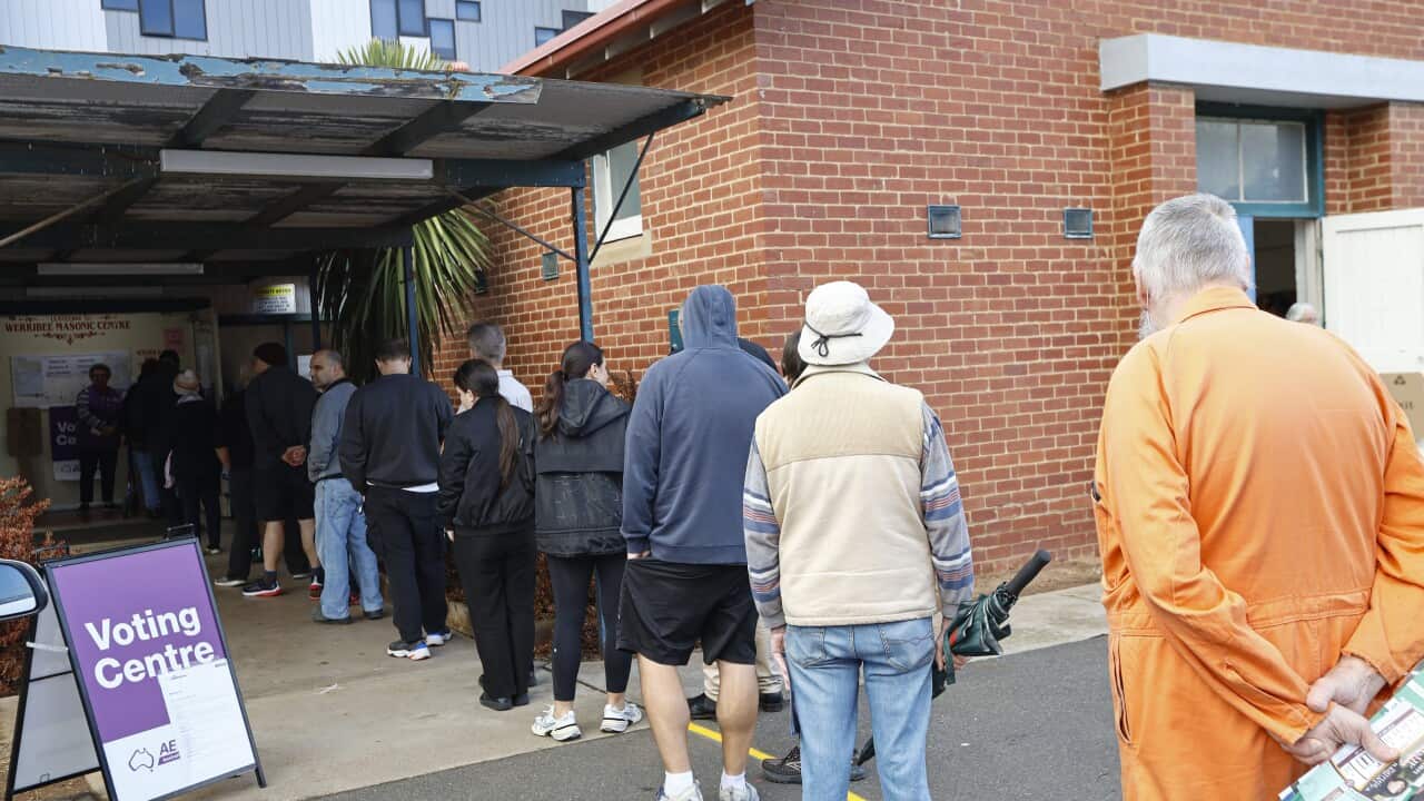 A group of people queueing up at a voting centre.