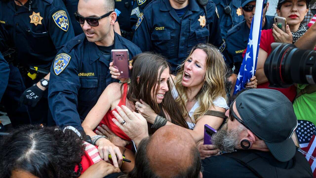 Heidi Muñoz Gleisner, left center, and Tara Thornton, right center, were removed from a demonstration in Sacramento on Friday.