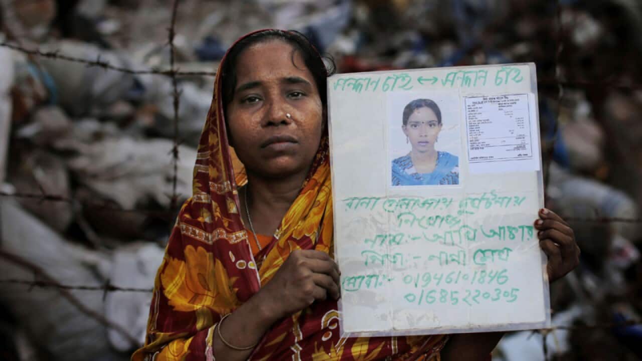 A woman holds a picture of her daughter who was missing.