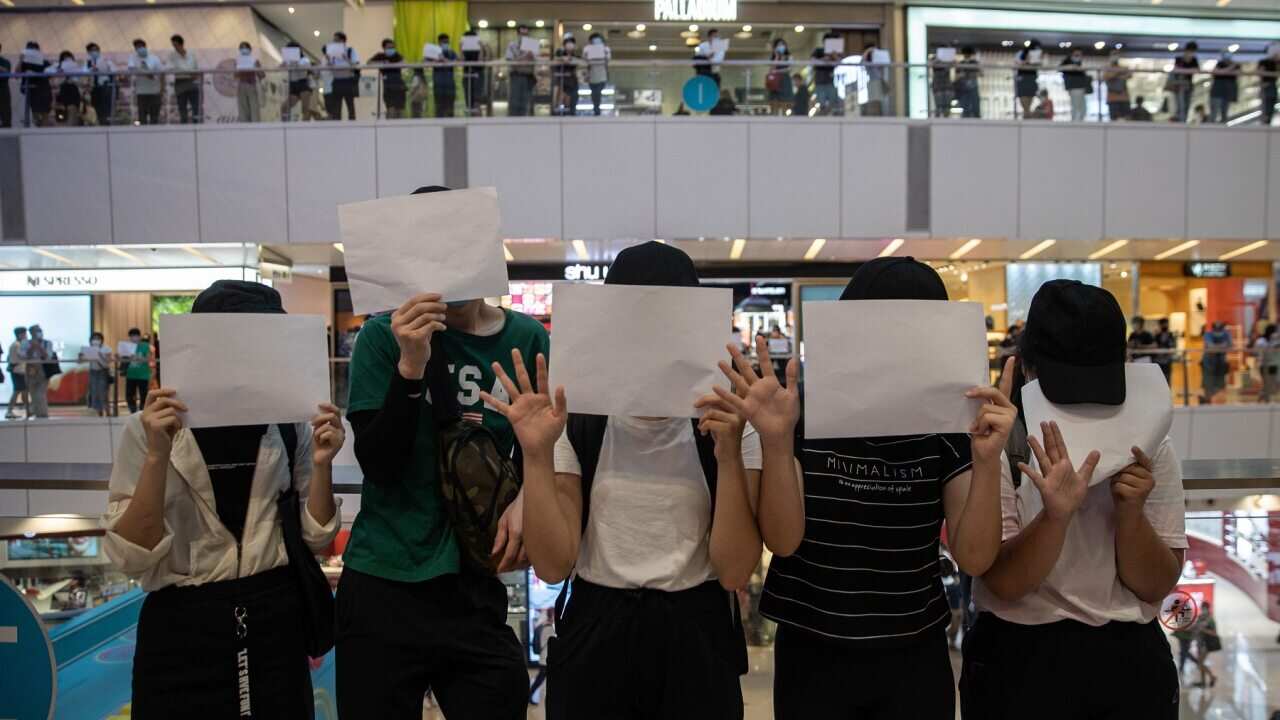 Protesters display sheets of plain white paper during a protest in a shopping mall in Hong Kong on 6 July 2020.