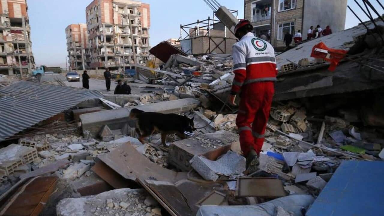 A rescue worker searches debris for survivors