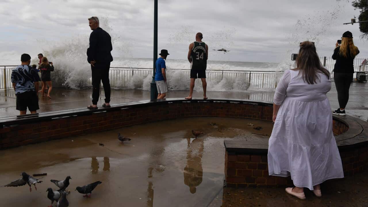 Onlookers watch as large waves pound the promenade and ocean baths at Bronte Beach in Sydney.