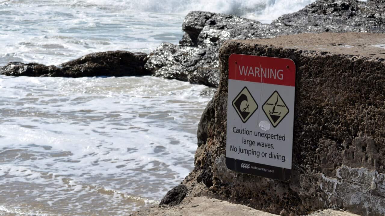 A sign warns again dangerous surf conditions at a beach