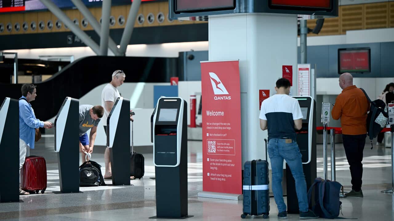 Travellers at self check in kiosk at Sydney airport