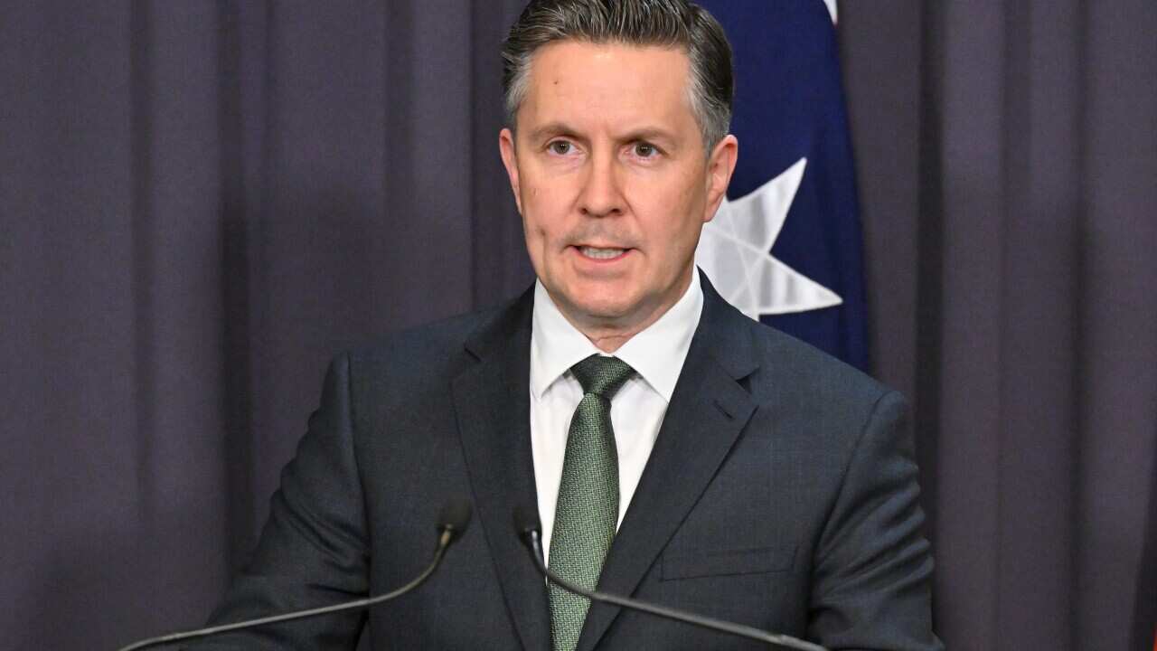 Health Minister Mark Butler at a podium.