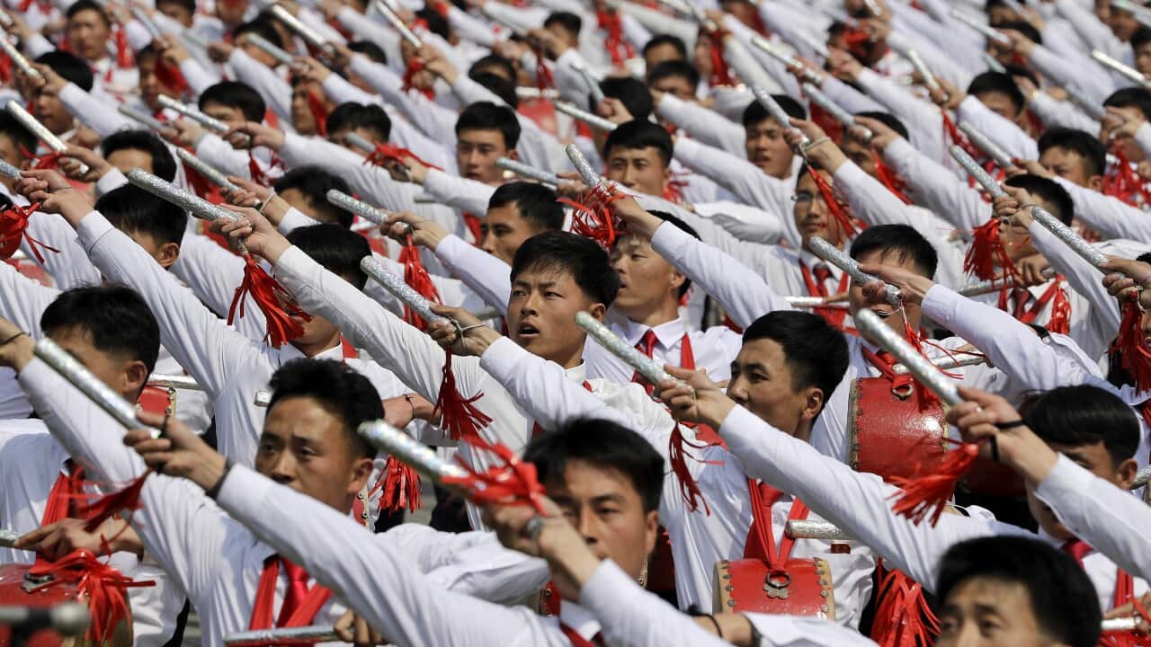 North Korean men beat drums as they parade across Kim Il Sung Square during a military parade on Saturday.