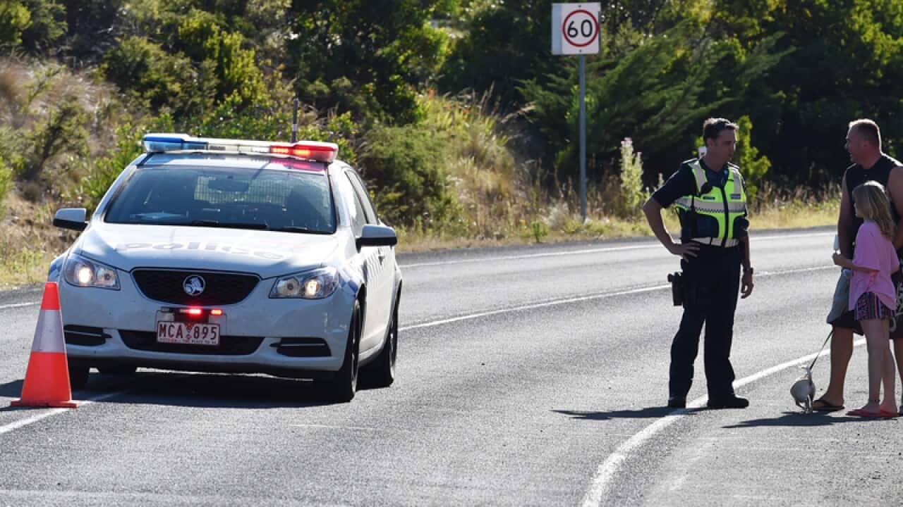 Police direct traffic at a road block on the Great Ocean Road