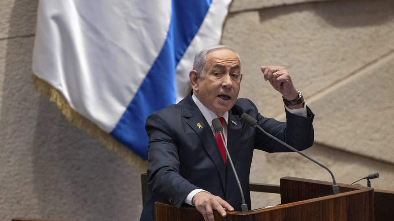 Benjamin Netanyahu shakes his fist as he speaks at a lectern.