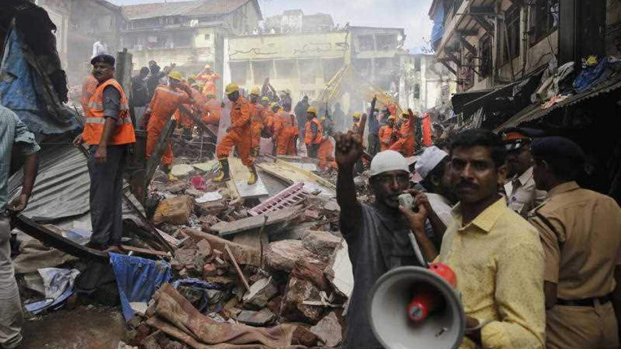 A rescue worker makes an announcement on a loudspeaker at the site of a building collapse in Mumbai, India, Thursday, Aug. 31, 2017.