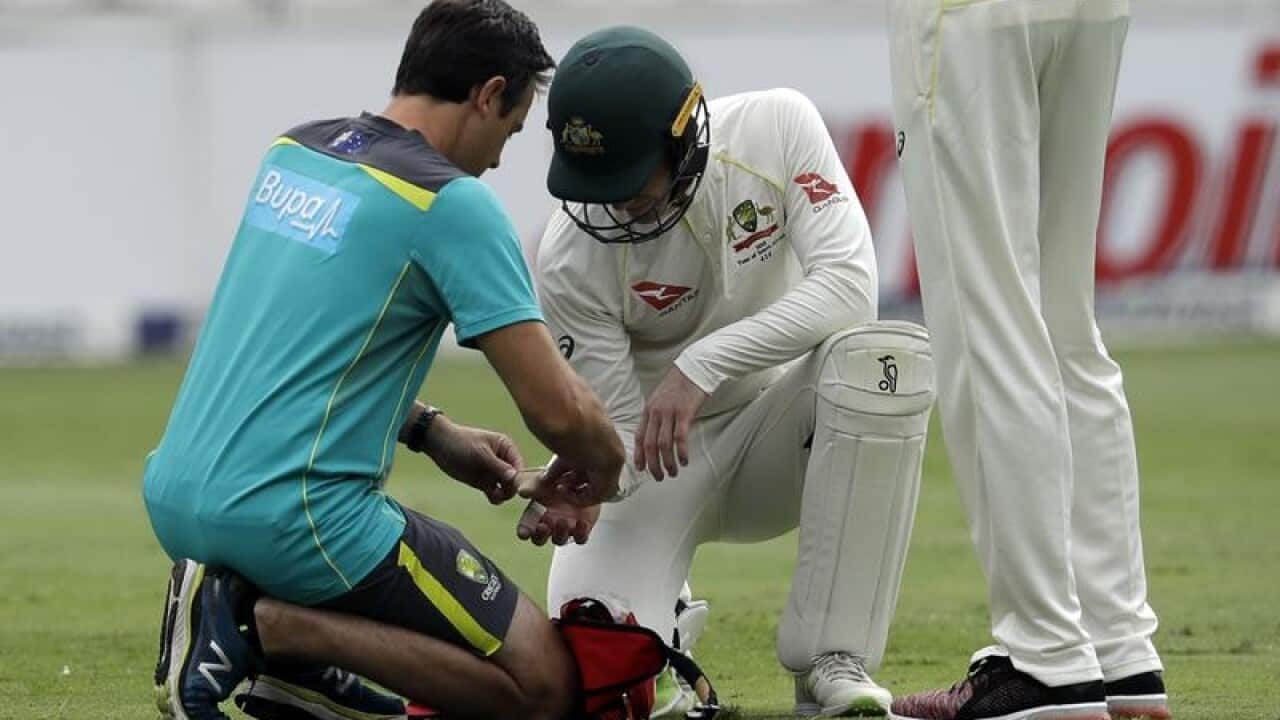 Australia's captain Tim Paine, right, receives treatment.
