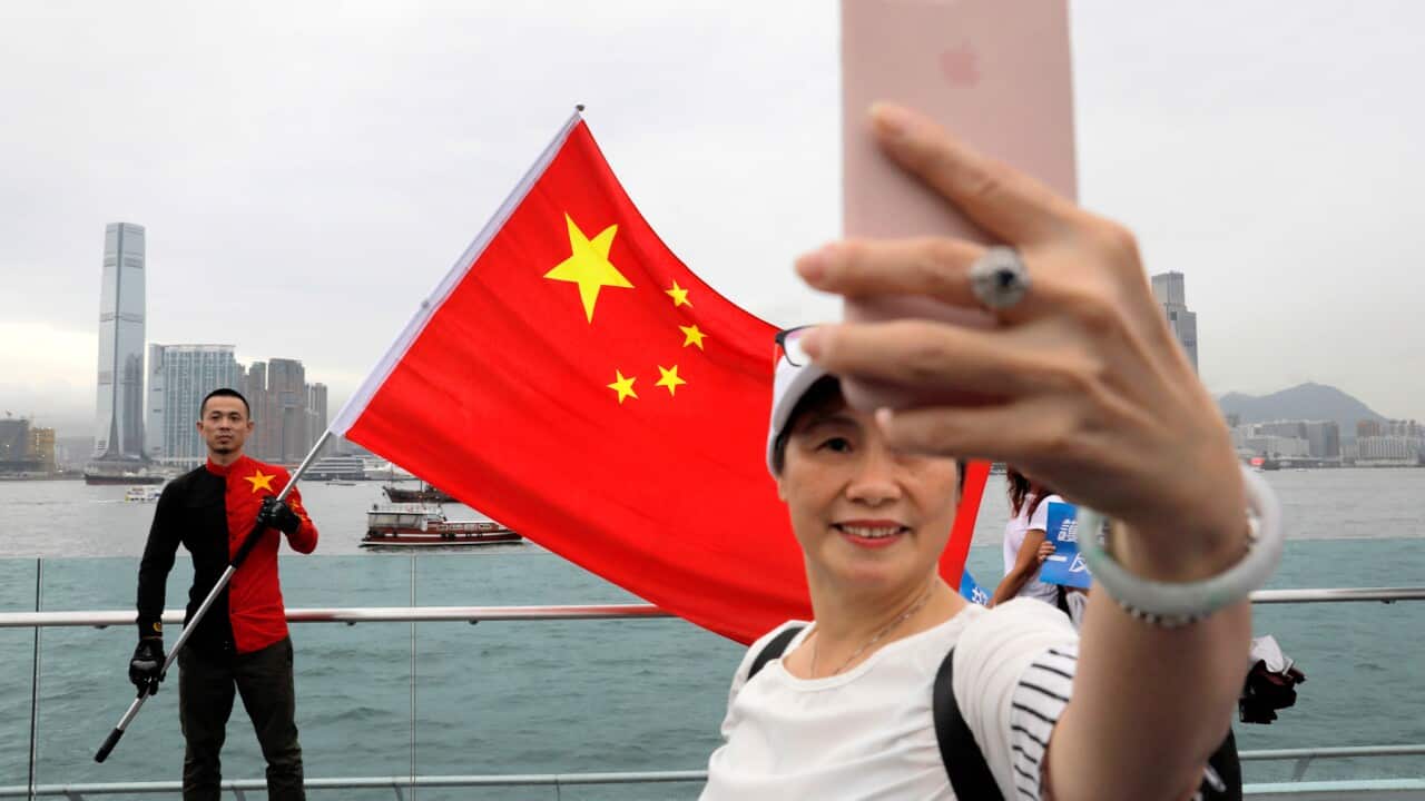 Pro-China supporters take a selfie with a Chinese national flag during a rally at a park in Hong Kong