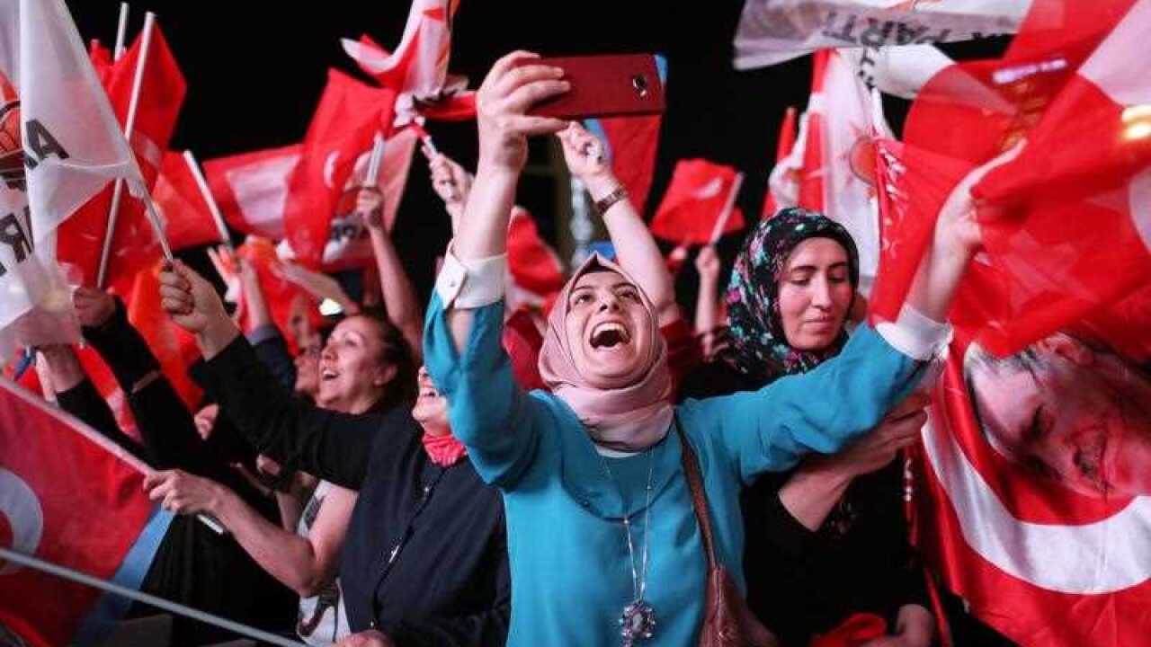 Supporters of Turkish President Erdogan hold Turkish and AK Party flags and celebrate after closing voting for the Turkish presidential election