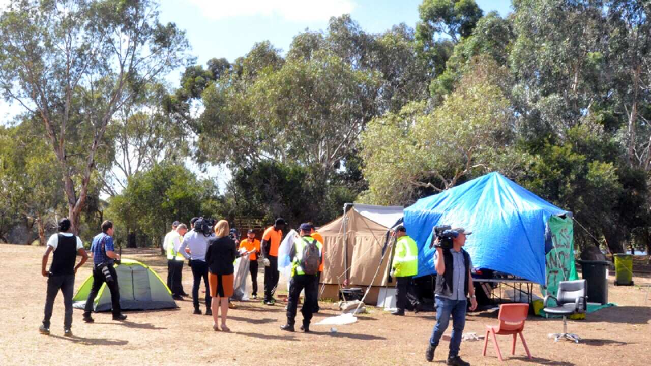 Police officers are seen as tents are removed from Heirisson Island