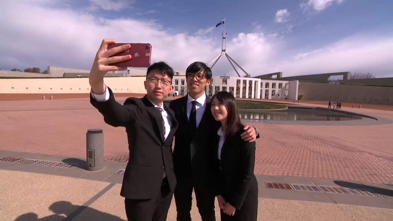 The student protesters take a photo outside Parliament House.
