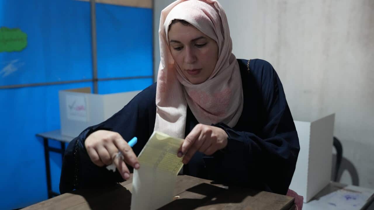 A woman casts her ballot at a polling station