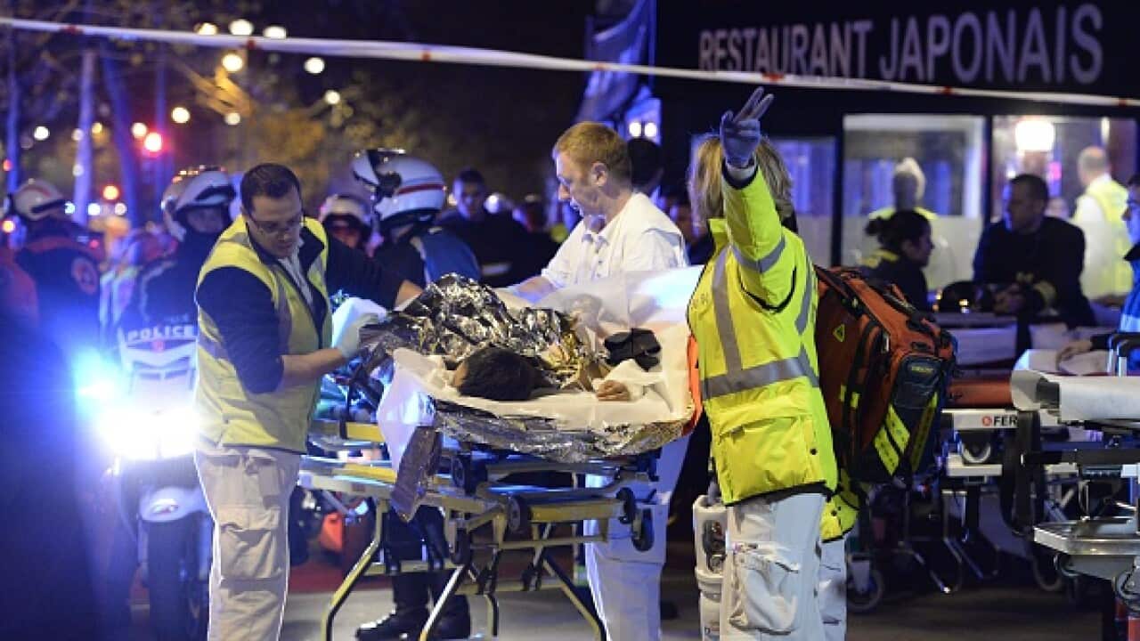 Rescuers evacuate an injured person near the Bataclan concert hall in central Paris, early on November 14, 2015. (Photo credit should read MIGUEL MEDINA/AFP/Getty Images)