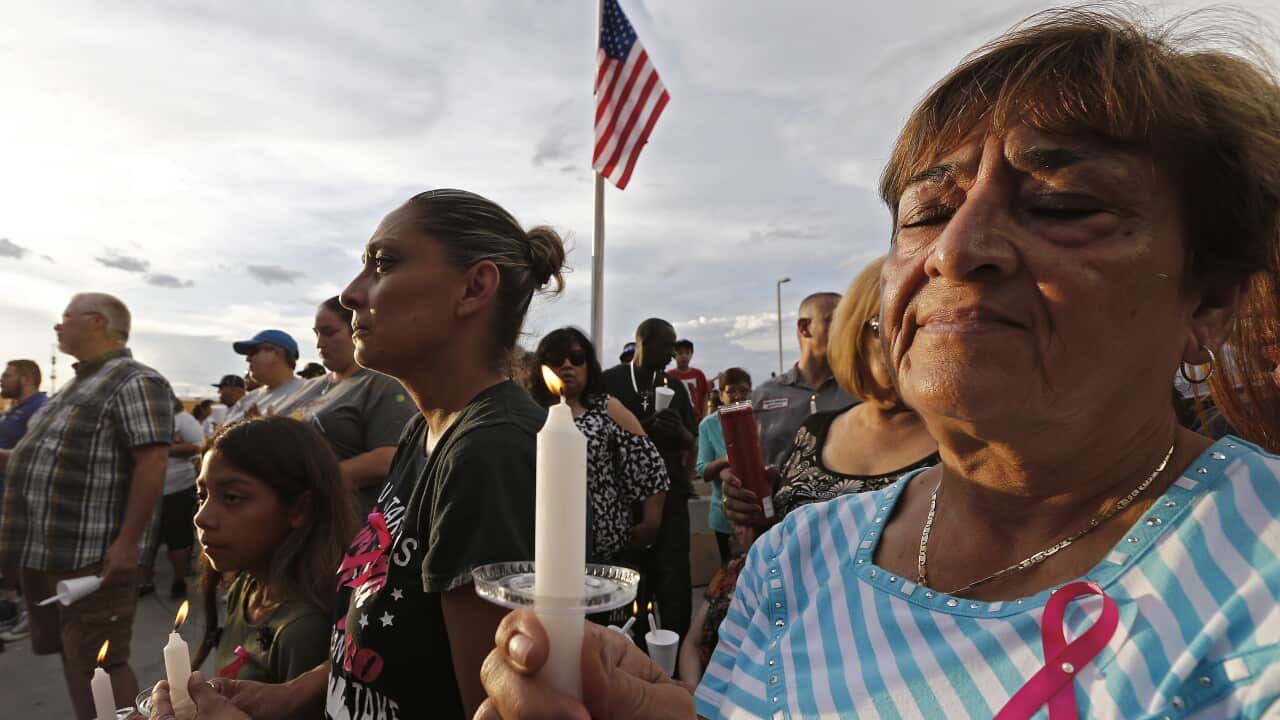People hold candles at a vigil for the victims of the El Paso shooting.