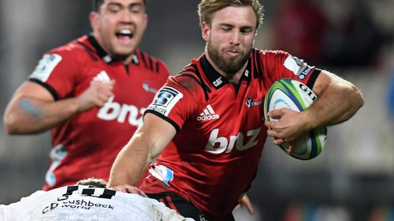 Braydon Ennor of the Crusaders fends off Robert du Preez of the Sharks
