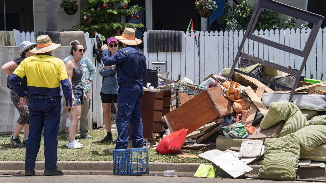 Volunteers arrive to help clean up a flooded house at Machans Beach in Cairns