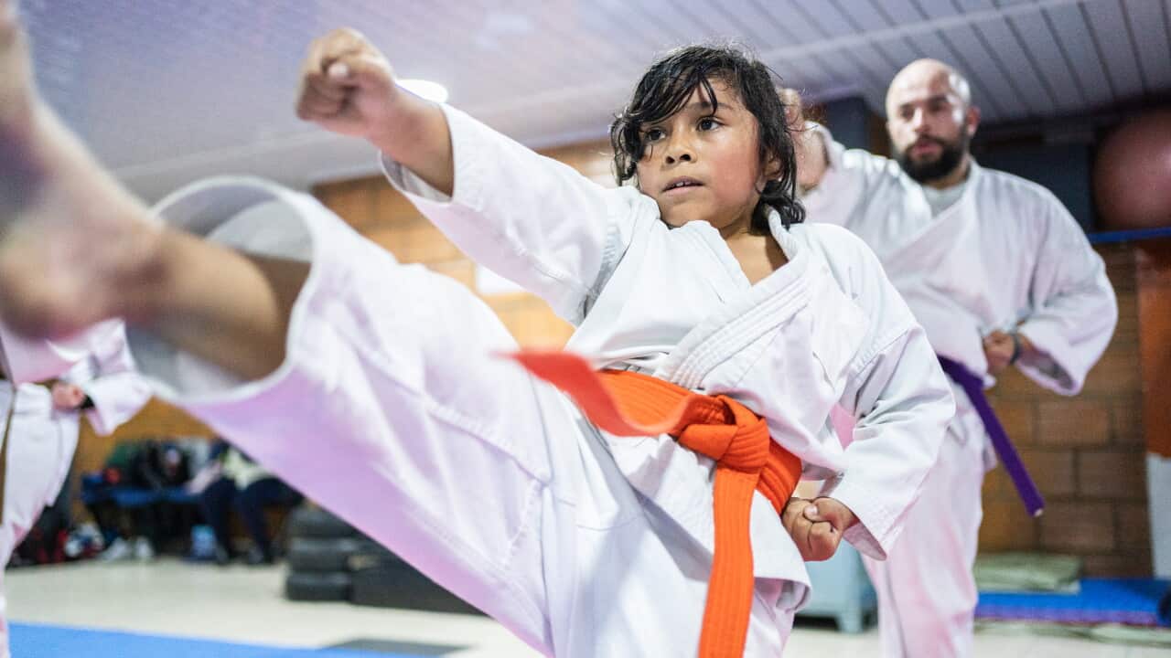 Child boy punching and kicking the air during a karate class