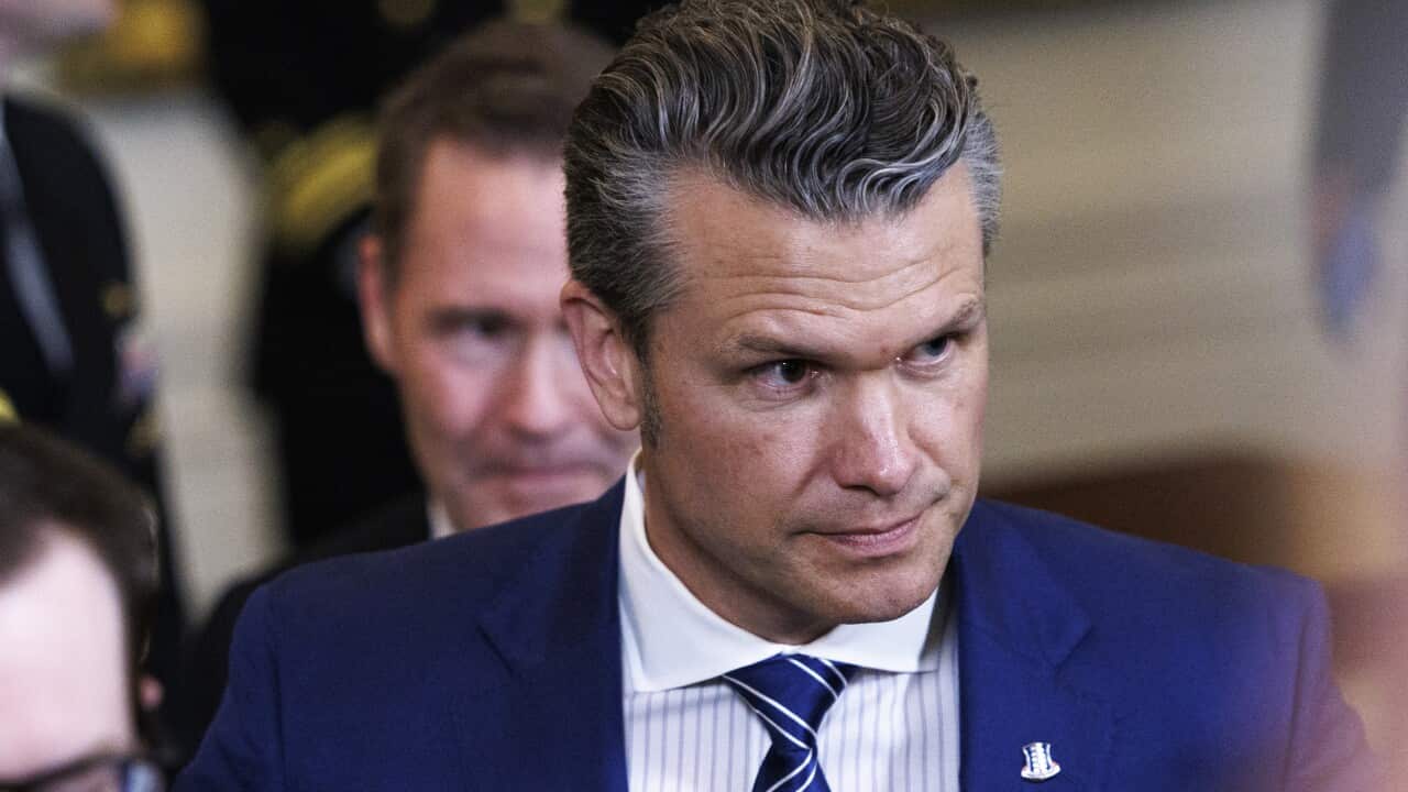 A man in a blue blazer, white shirt and blue tie.