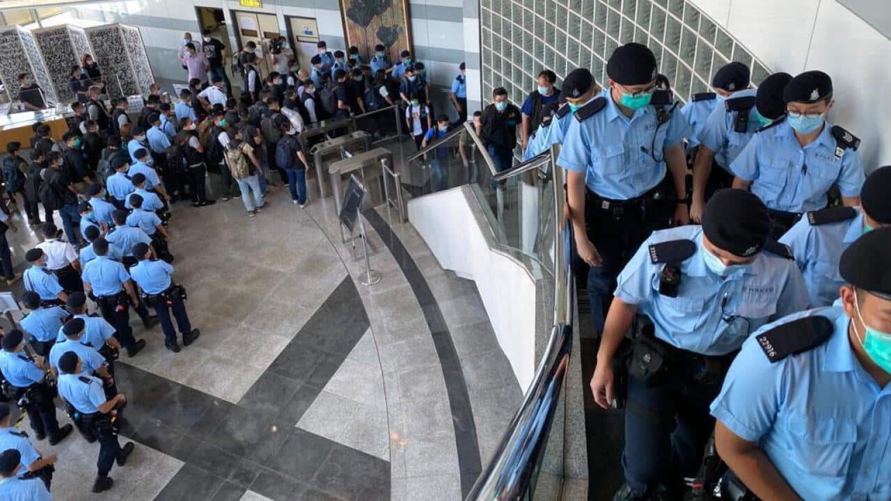 Scores of Hong Kong police raid the Apple Daily newspaper in Hong Kong.