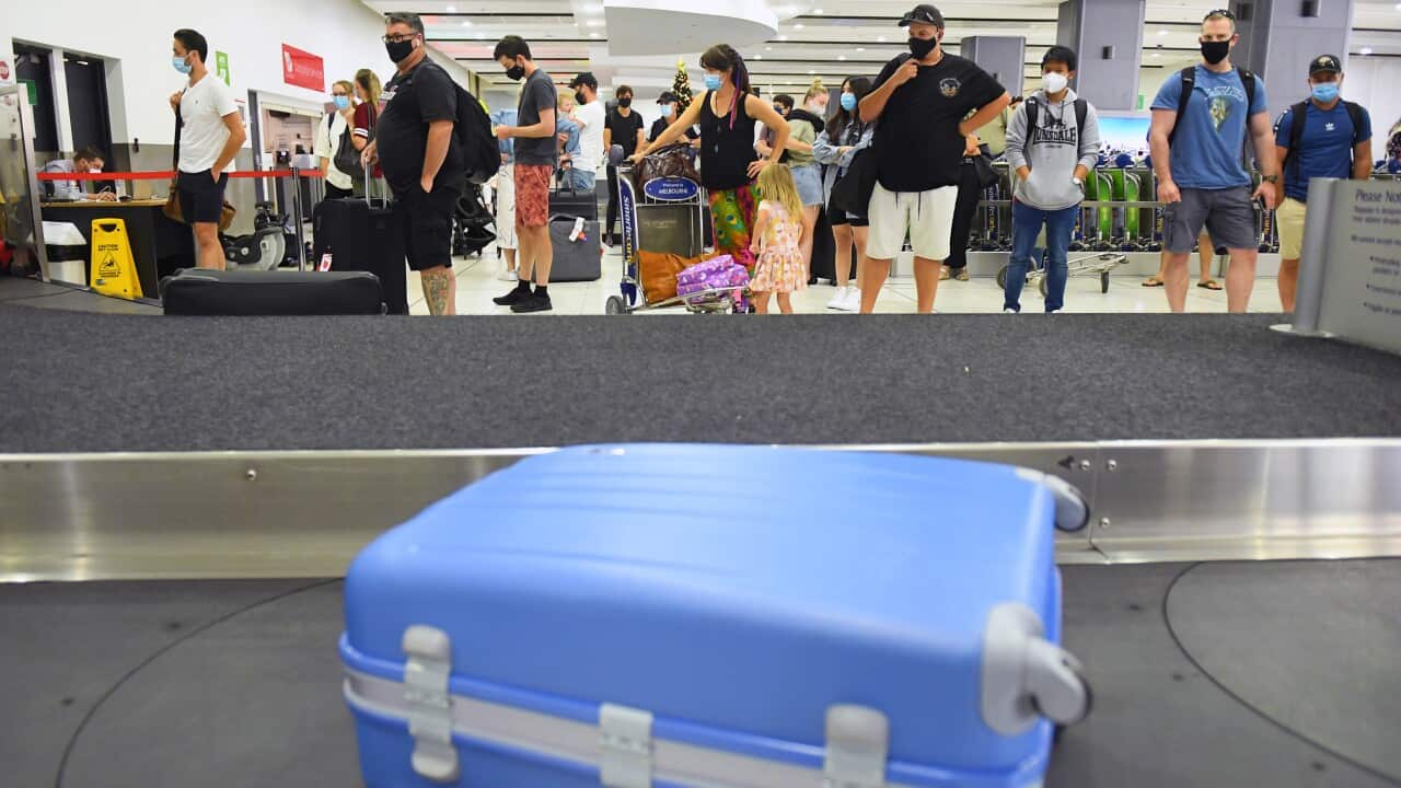People are seen in the baggage collection area after arriving on a Virgin Australia flight, Melbourne, Friday, January 8, 2021.