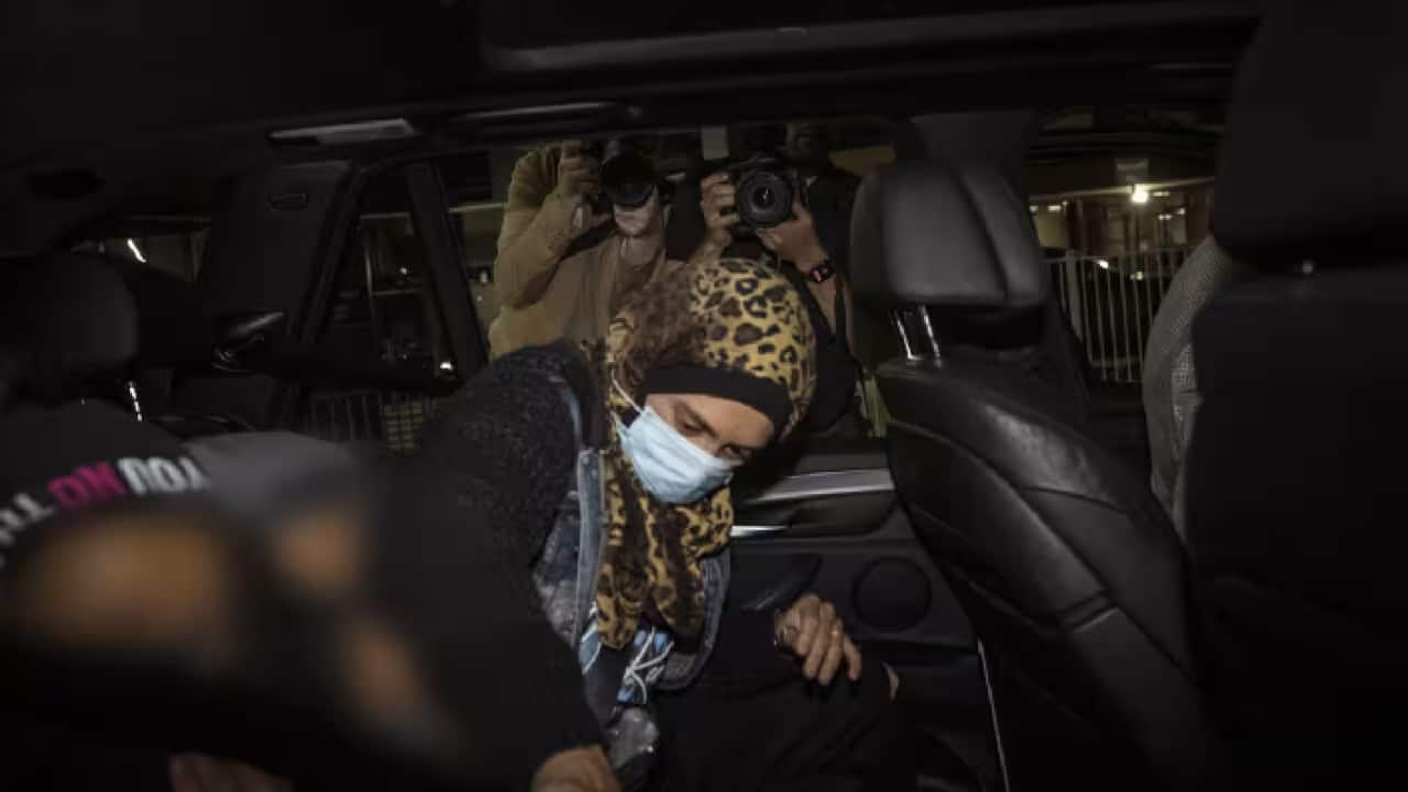An Islamic State-linked family get into a car after arriving at Melbourne international Airport.png