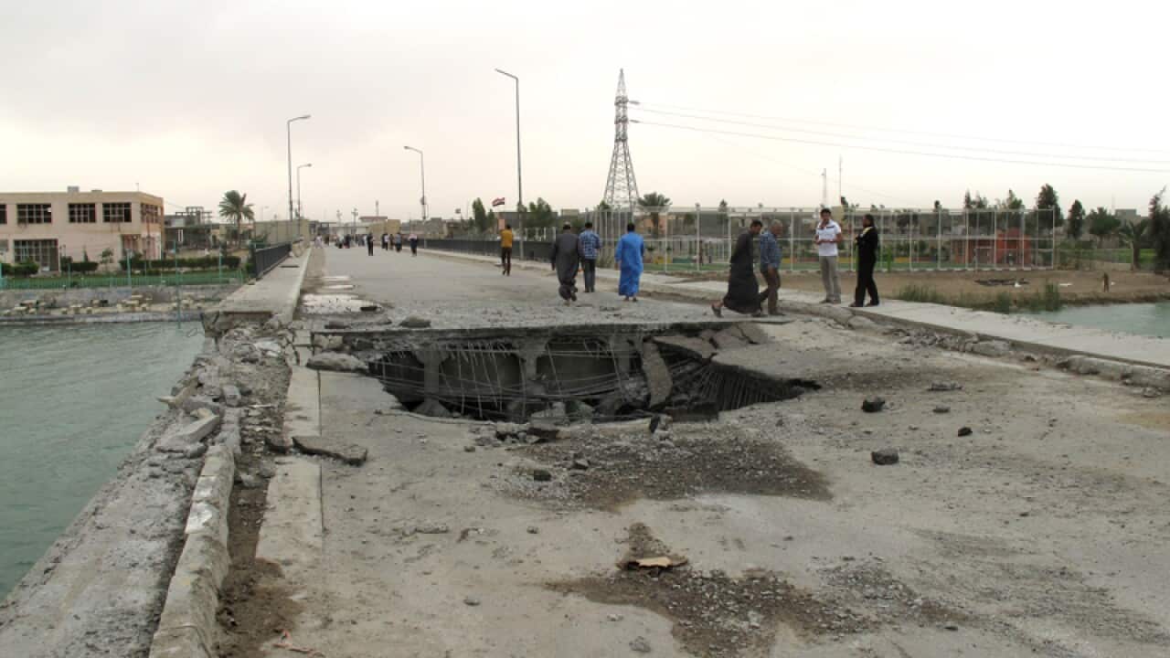 A gaping hole following a suicide bombing along a bridge