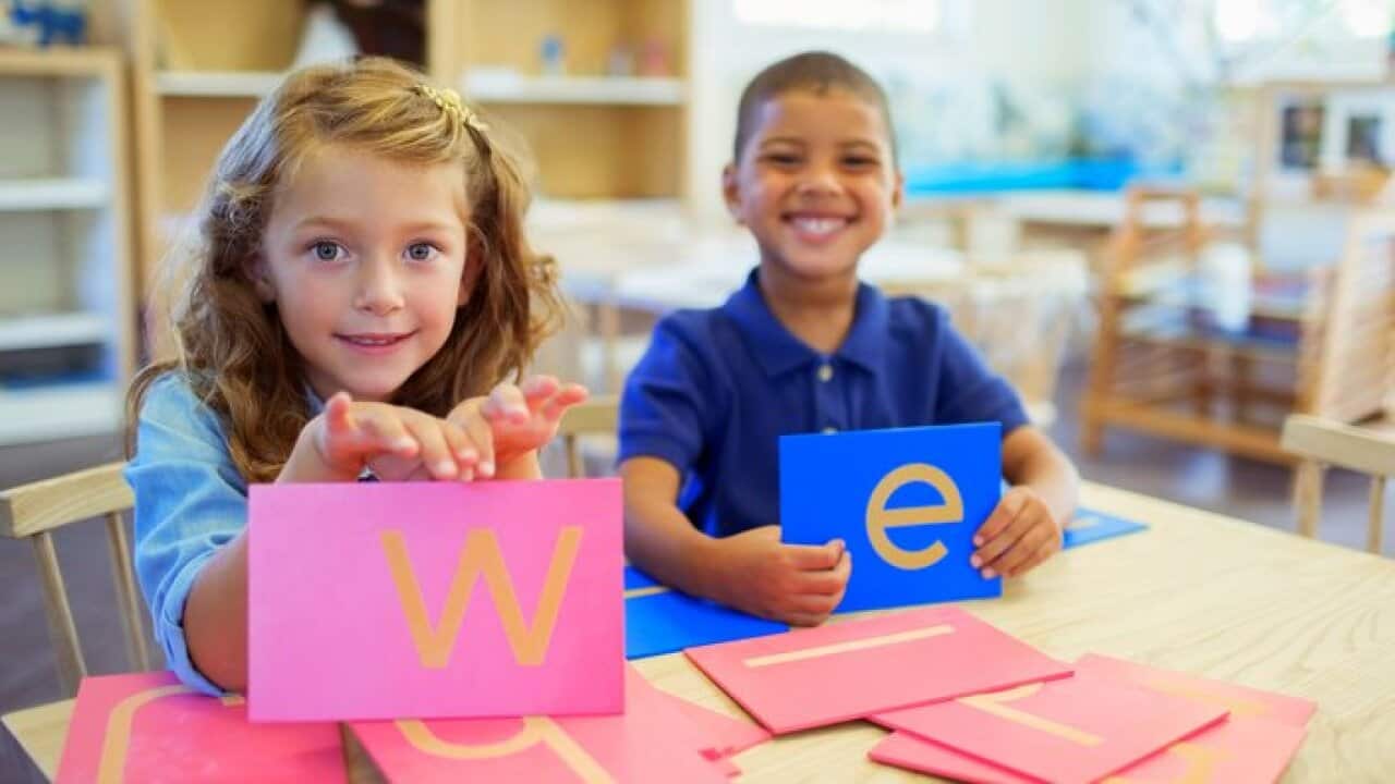 Students holding letters in classroom
