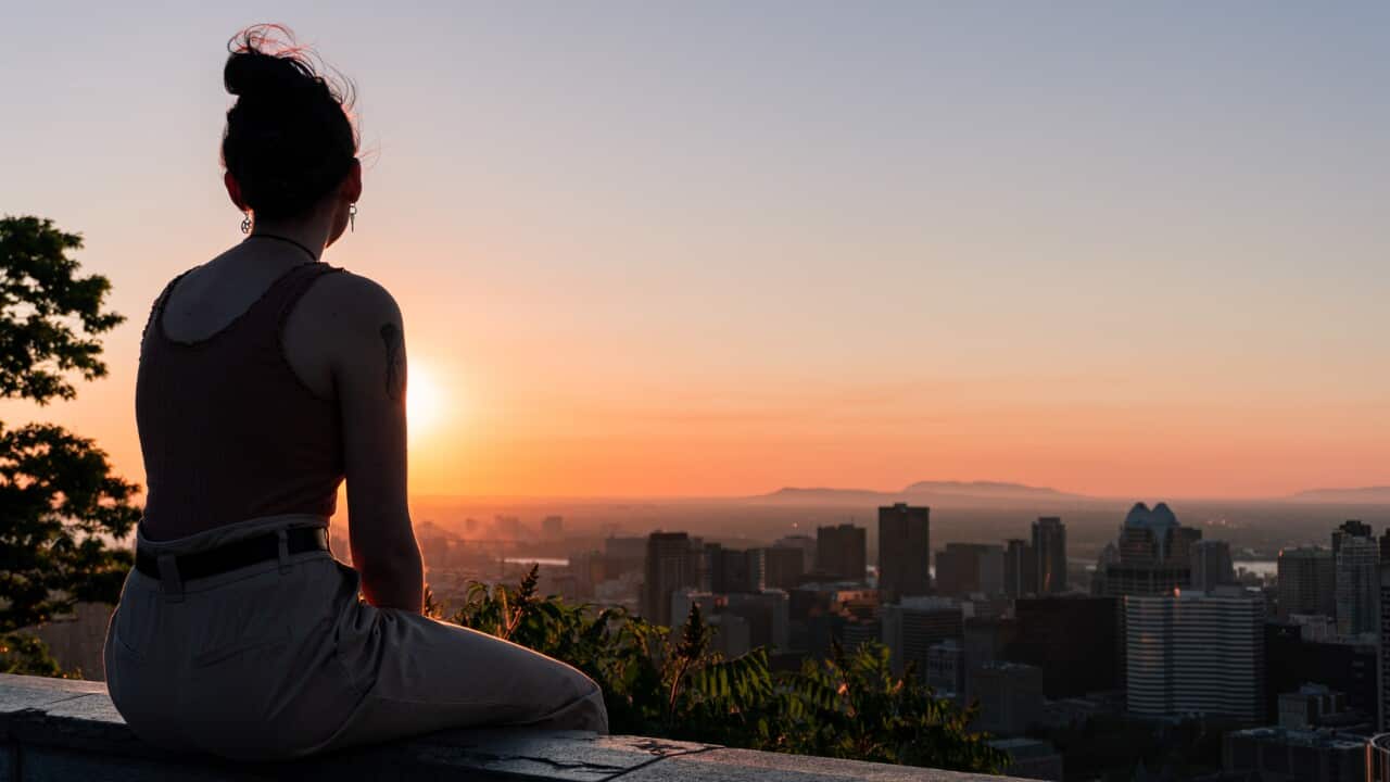 Women Looking At Cityscape Against Sky During Sunset